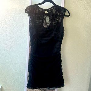 Short lace topped black dress with ruched mesh overlay.